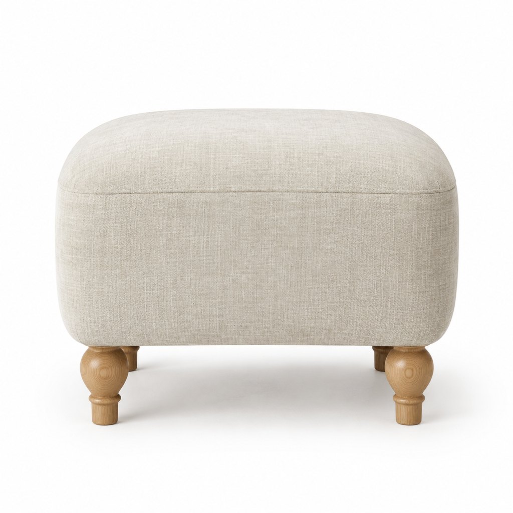 Birka oatmeal linen ottoman with oak legs in bright daylight